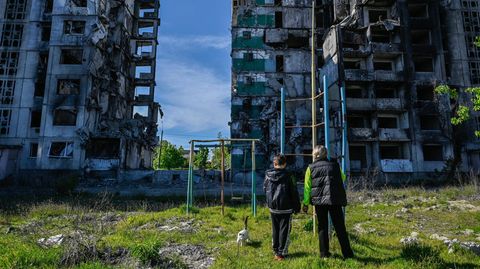 Alltag im Krieg: Menschen stehen vor zerstörten Häusern in Borodjanka nordöstlich von Kiew