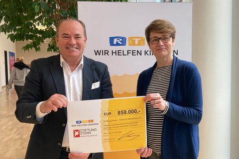 Wolfram Kons überreicht einen Scheck über 859.000 Euro an Catrin Boldebuck