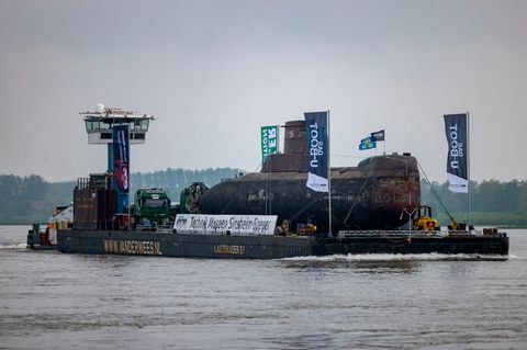 Das U-Boot auf einem Schwimmponton passiert auf dem Rhein den Ort Bimmen