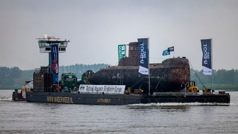 Das U-Boot auf einem Schwimmponton passiert auf dem Rhein den Ort Bimmen