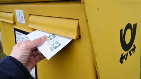 Deutsche Post: Ein Brief wird in einen Briefkasten gesteckt