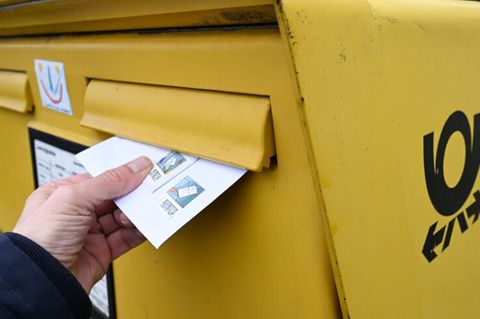 Deutsche Post: Ein Brief wird in einen Briefkasten gesteckt