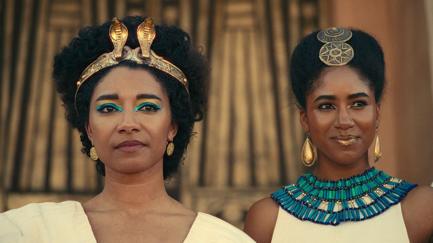 Cleopatra im Vordergrund mit Haarschmuck, weibliche Begleiterin im Hintergrund, ebenfalls mit viel Schmuck