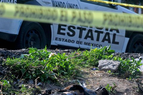 Ein abgesperrter Tatort in Mexiko, dahinter ein Polizeiauto