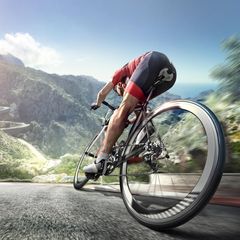 Wattmesser Rennrad: Ein Mann radelt auf seinem Rennrad durch eine Berglandschaft