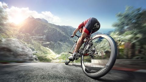 Wattmesser Rennrad: Ein Mann radelt auf seinem Rennrad durch eine Berglandschaft