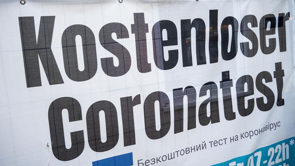 Ein Banner "Kostenloser Coronatest" hängt an einem Corona-Testzentrum
