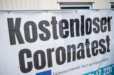 Ein Banner "Kostenloser Coronatest" hängt an einem Corona-Testzentrum