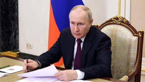 Russlands Präsident Wladimir Putin sitzt am schreibtisch