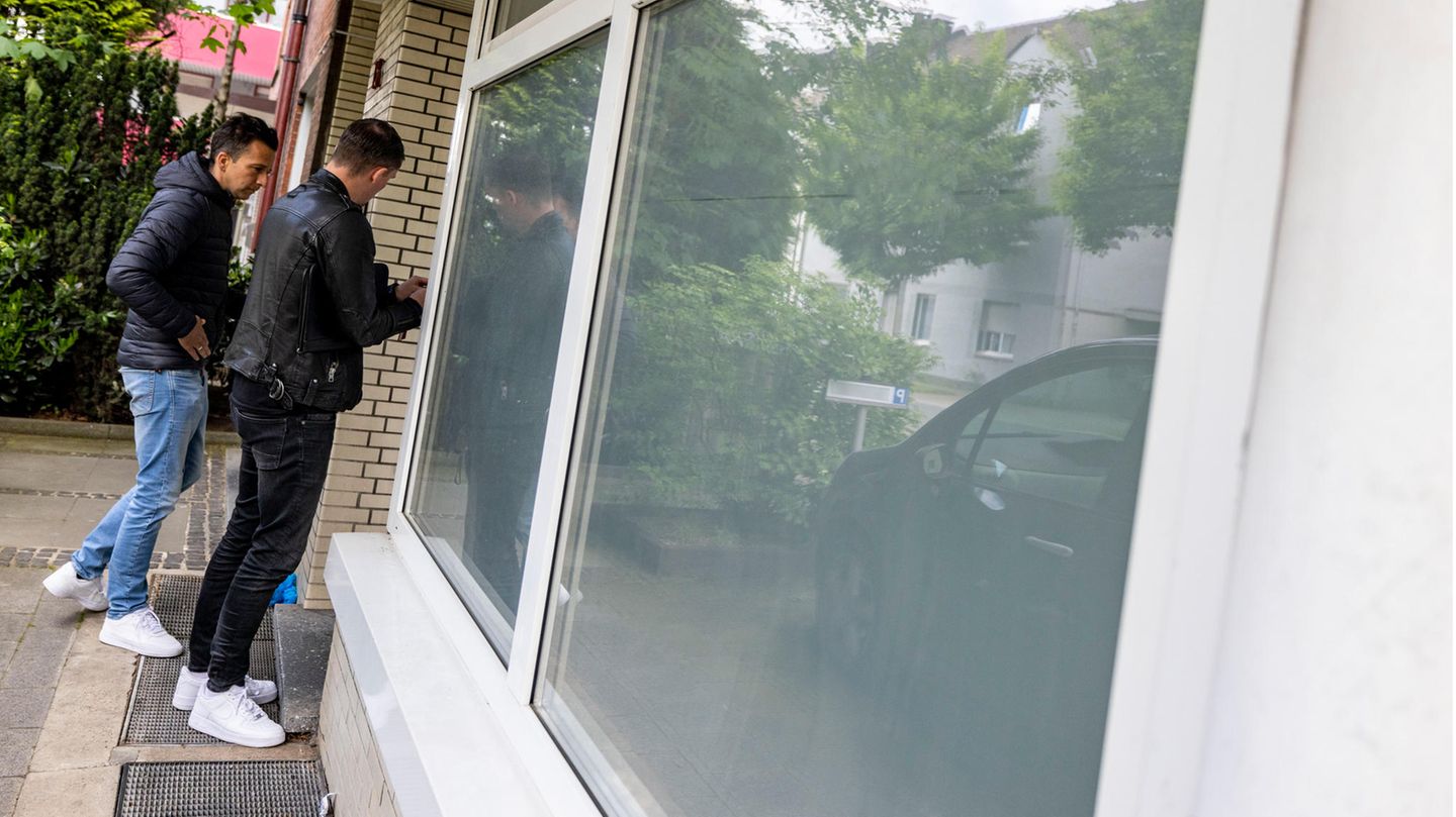 Zwei zivile Beamte der Kriminalpolizei betreten die Wohnung in Herten, in der die Leichen einer Frau und zweier Mädchen entdeckt wurden