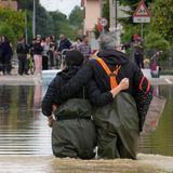Ein Paar geht auf einer überfluteten Straß