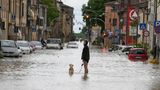 In Castel Bolognese geht ein Mann mit seinem Hund auf einer überschwemmten Straße spazieren