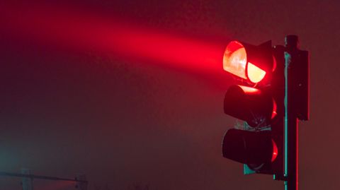 Im Dunkeln wirft eine Ampel in Deutschland rotes Licht