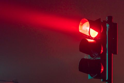 Im Dunkeln wirft eine Ampel in Deutschland rotes Licht