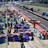 Aus einer VIP-Lounge über den Boxen fotografiert. Gleich findet das erste Qualifying statt. Die Rennwagen kommen aus den Boxen und spiegeln sich im Glas der VIP-Räume.