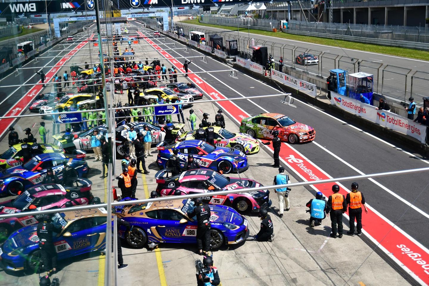 Aus einer VIP-Lounge über den Boxen fotografiert. Gleich findet das erste Qualifying statt. Die Rennwagen kommen aus den Boxen und spiegeln sich im Glas der VIP-Räume.