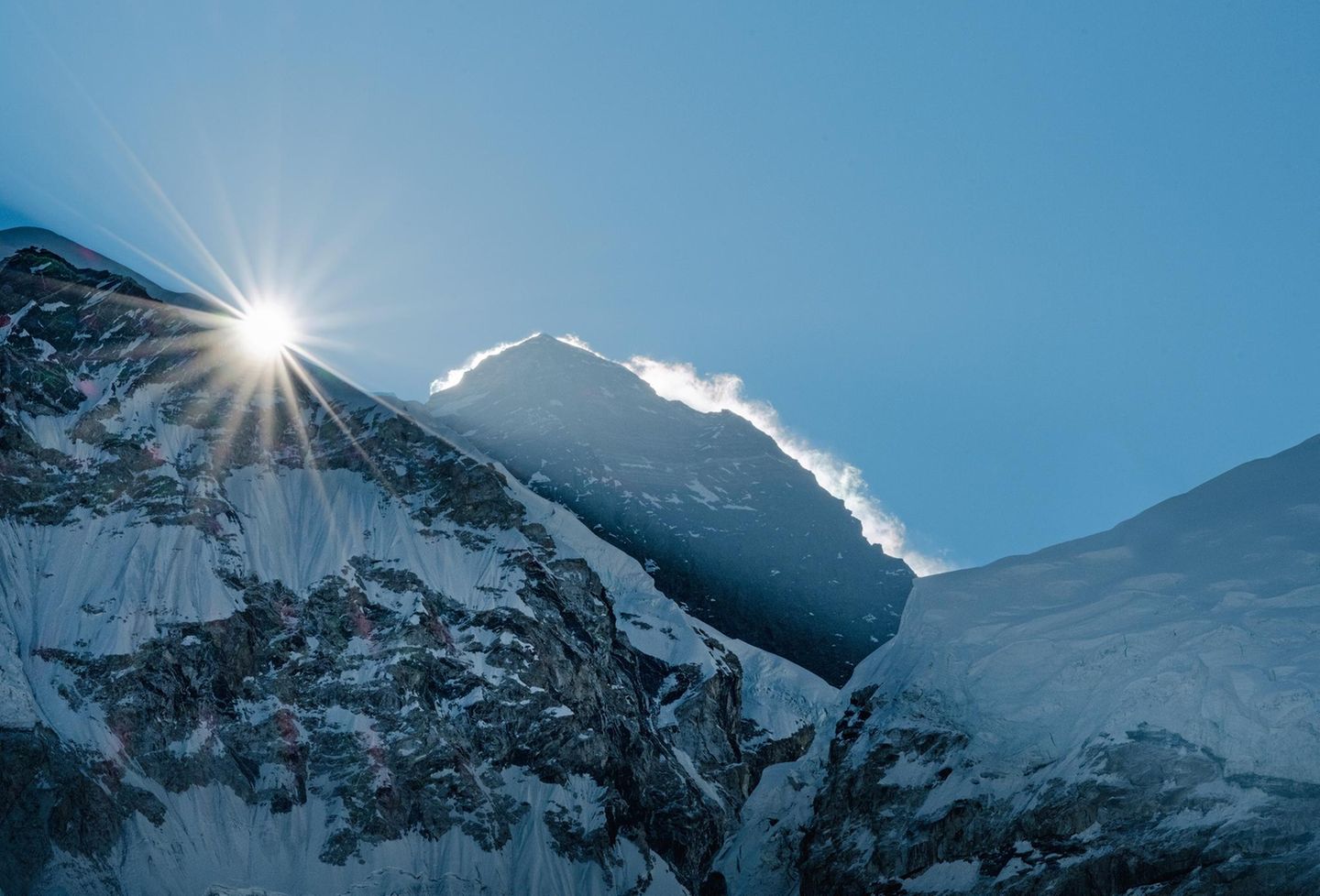 Hinter den Gipfeln kommt die Sonne hervor