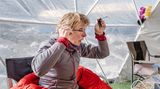 Eine Frau sitzt im Zelt und schminkt sich mit Wimperntusche