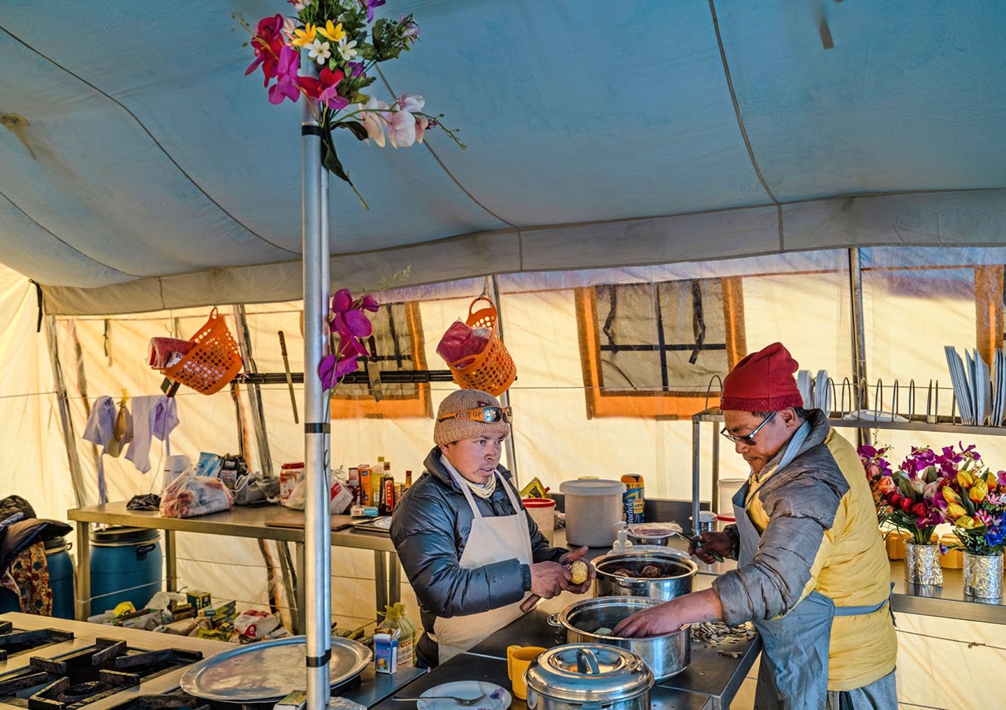 Zwei einheimische stehen in einem Küchenzelt und kochen