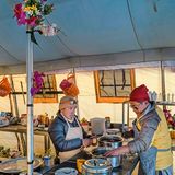 Zwei einheimische stehen in einem Küchenzelt und kochen