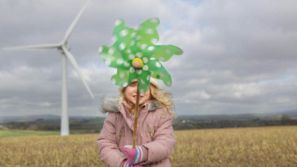 Windenergie: Ein Kind hält ein grünes Windrad