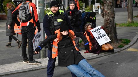 Während einer Demonstration in Berlin wird eine Unterstützerin der Letzten Generation von einem Polizisten von der Straße gezogen. (Archivbild) Am Mittwochmorgen wurden bei einer Razzia mehrere Gebäude durchsucht.