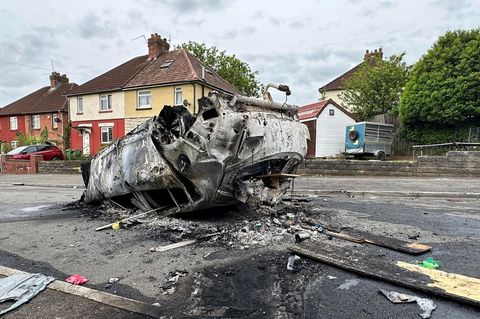 Ein ausgebranntes Autowrack liegt auf dem Dach