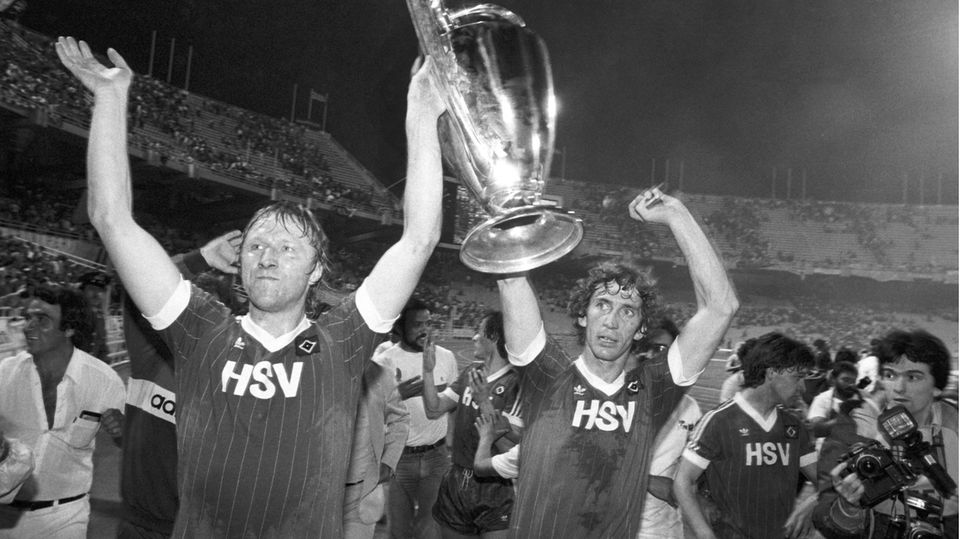 Stolz recken die HSV-Spieler Horst Hrubesch (l.) und Ditmar Jakobs den Pokal der Landesmeister in die Höhe