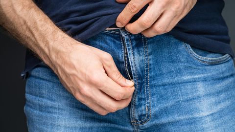 Ein Mann zieht am Reissverschluss seiner Hose