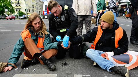 Aktivisten der "Letzten Generation" kleben sich in Berlin am Asphalt fest 