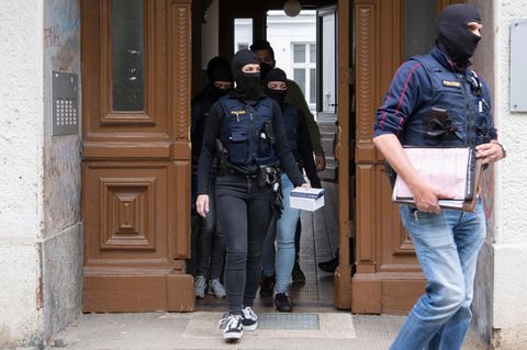 Vermummte Polizistinnen und Polizisten verlassen nach Durchsuchungen bei der "Letzten Generation" einen Altbau in Berlin