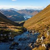 Ein Fluss fließt in den Loch Long in Schottland