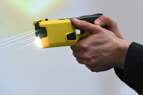 Ein Mann hält eine Taser-Waffe in beiden Händen
