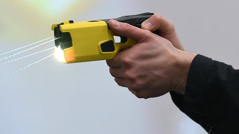 Ein Mann hält eine Taser-Waffe in beiden Händen