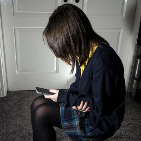 A girl stares at a cell phone