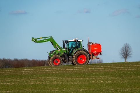 Ein Traktor mit Düngerstreuer (Symbolbild)