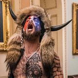 Mit seinem Kopfschmuck gehört Jacob Chansley (M.) wohl zu den bekanntesten Erstürmern des Kapitols. Vor Gericht bekannte er sich der Behinderung eines offiziellen Verfahrens für schuldig und räumte ein, die Menge mit einem Megafon angestachelt zu haben. Ein Bezirksgericht verurteilte ihn daraufhin im November 2021 zu 41 Monaten – also drei Jahren und fünf Monate – Gefängnis.