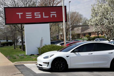 Tesla Schild des Standorts in Illinois, davor steht ein Tesla-Auto.