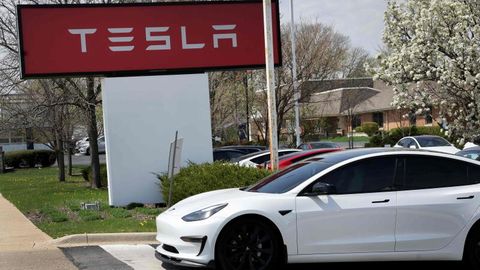 Tesla Schild des Standorts in Illinois, davor steht ein Tesla-Auto.