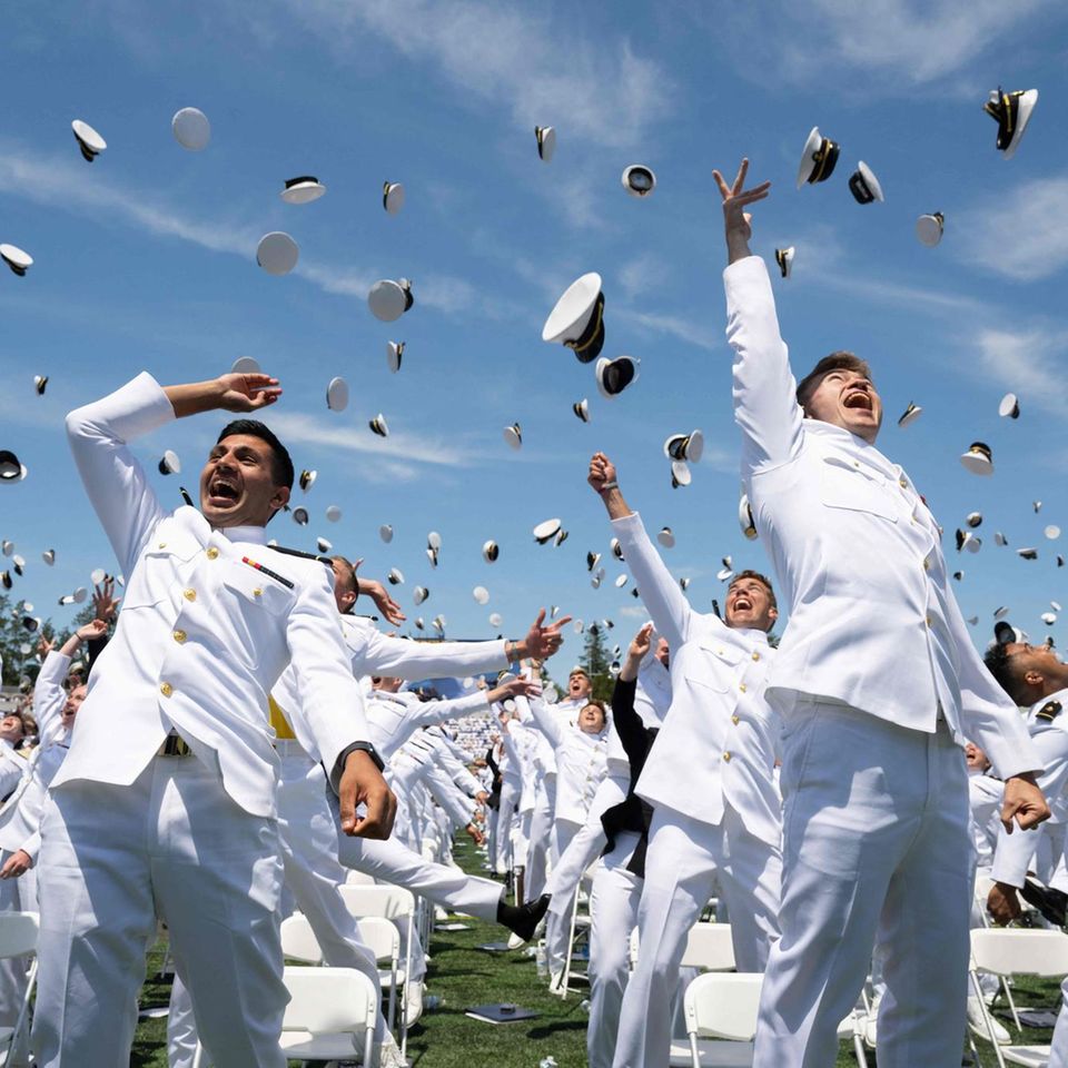 Annapolis, USA. Jetzt ist Party angesagt. Die Offiziersabsolventen der Navy Akademie werfen ihre Mützen in in die Luft.