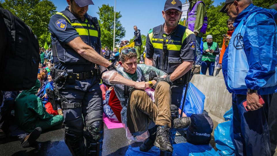Die Polizei trägt Aktivisten von Extinction Rebellion weg, die die A12 in Den Haag blockieren