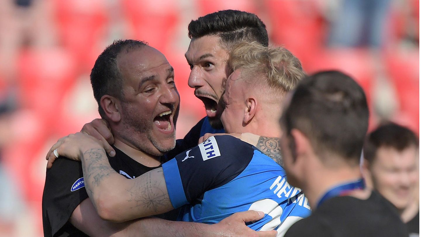 Heidenheims Trainer Frank Schmidt (l.) jubelt mit seinen Spielern. Schmidt ist definitiv der Vater des Erfolgs. Er übernahm Heidenheim 2007 als Trainer in der Oberliga. Seitdem ging es stetig bergauf. Der Bundesliga-Aufstieg krönt seine Arbeit.