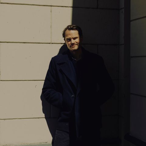 Fabian Hinrichs in schwarz gekleidet, halb im Schatten