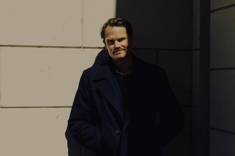 Fabian Hinrichs in schwarz gekleidet, halb im Schatten