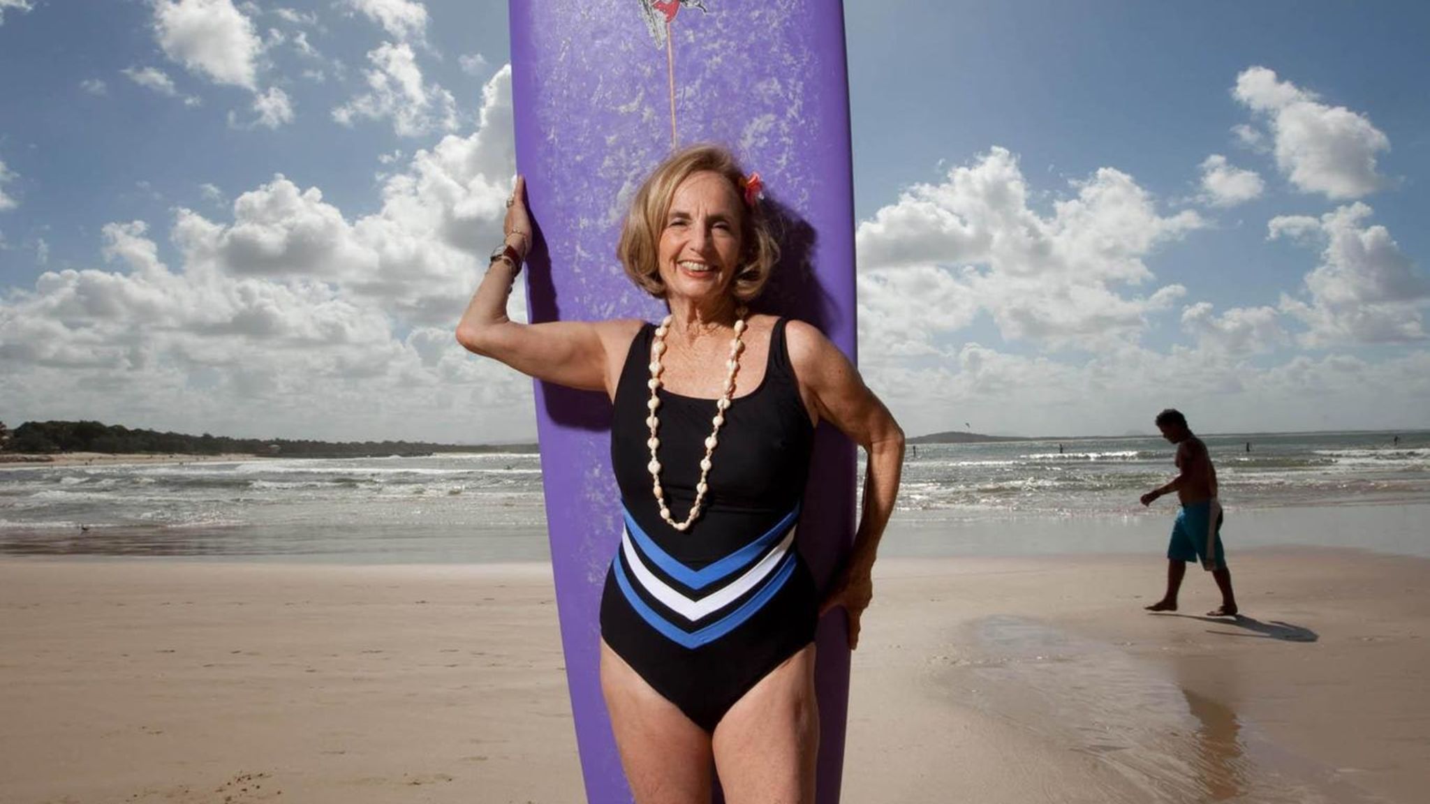 ein jung Frau im ein Baden passen auf das Strand durch das Meer