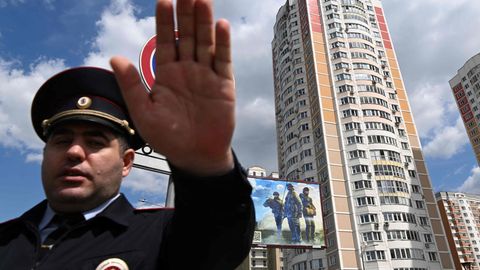 Ein Polizeibeamter sichert einen Bereich vor einem Wohnhaus in Moskau