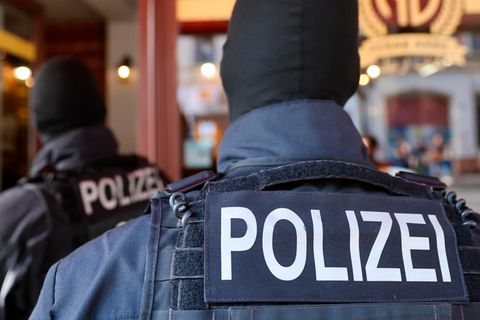 Polizeibeamte führen eine Razzia durch