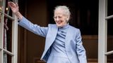 Königin Margrethe II. von Dänemark steht in fliederfarbenem Kostüm auf einem Balkon und winkt