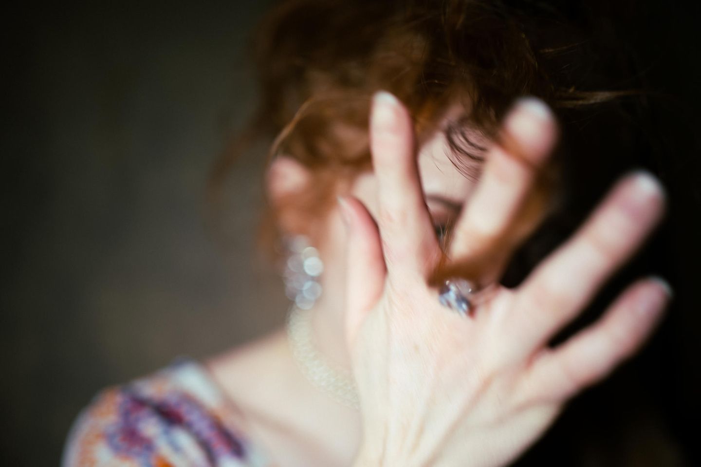 Eine Frau hält ihre Hand vor das Gesicht Eine Frau hält ihre Hand vor das Gesicht