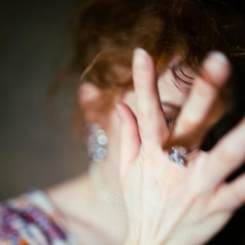 Eine Frau hält ihre Hand vor das Gesicht